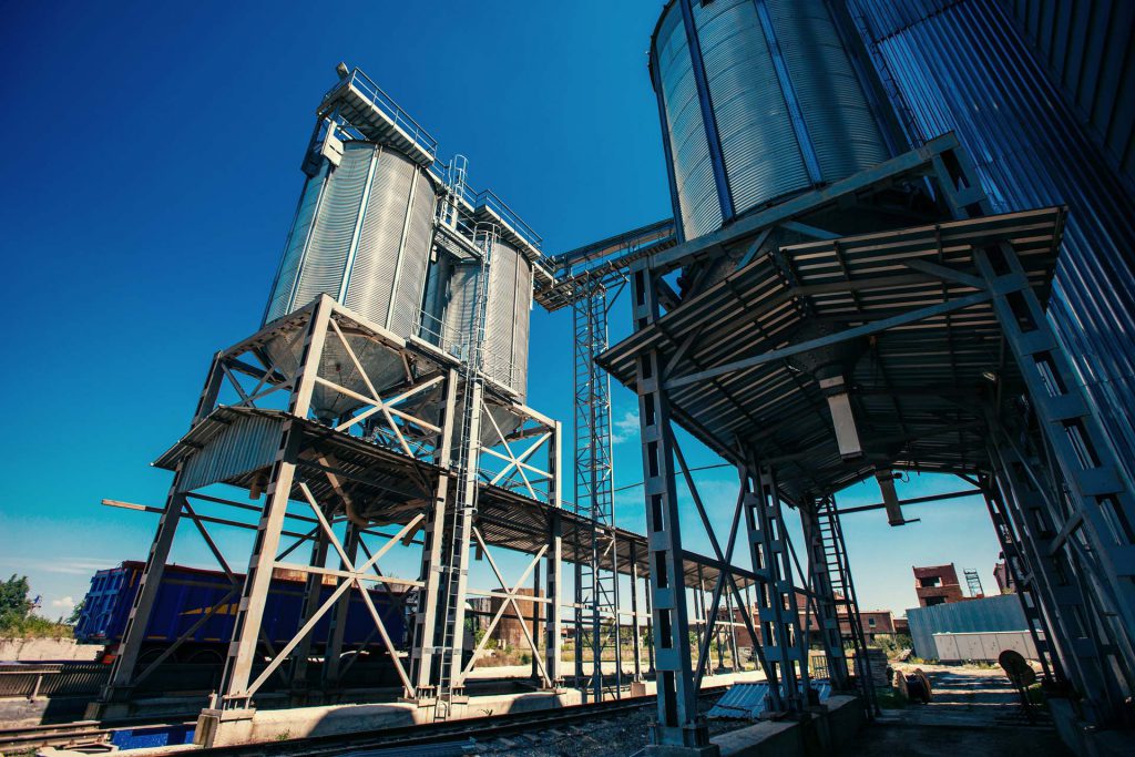 A set of grain silos that have IoT bin level monitoring devices tracking their grain levels.