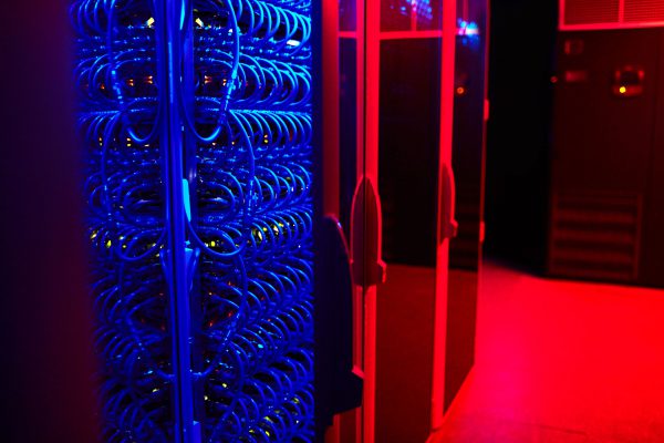 A server room bathed in red light is monitored using IoT temperature and humidity sensors.