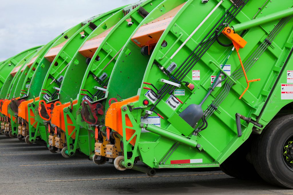 Green recycling trucks monitored by IoT asset trackers.