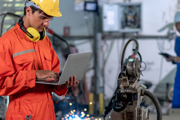 An industrial worker uses IoT montioring to diagnose a problem with a piece of machinery.