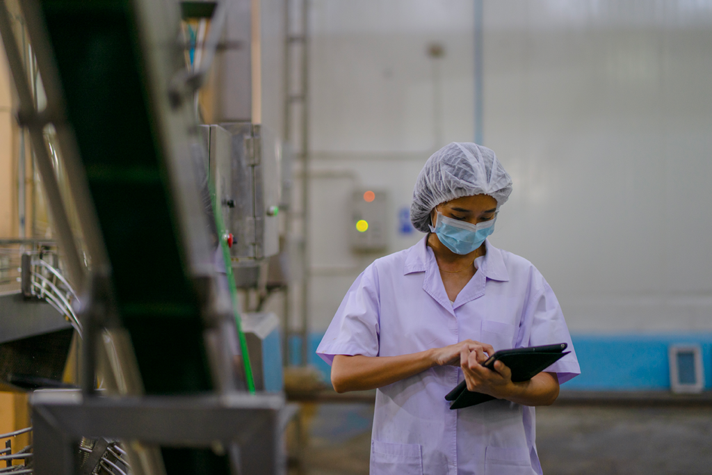 A factory worker evaluates a piece of machinery connected to the Internet of Things.